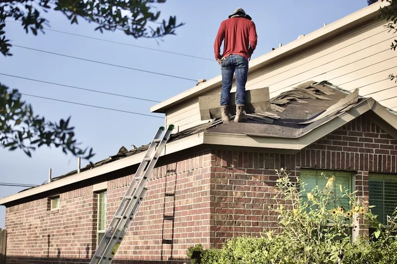 Professional roofer working on a residential roof in West Bolivar